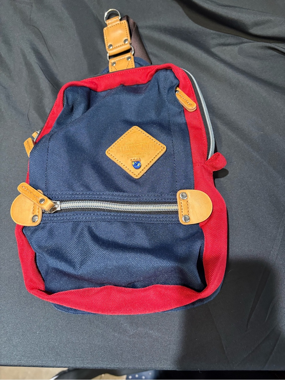 Harvest Label Sling Pack Pro in Navy Blue with red trim.